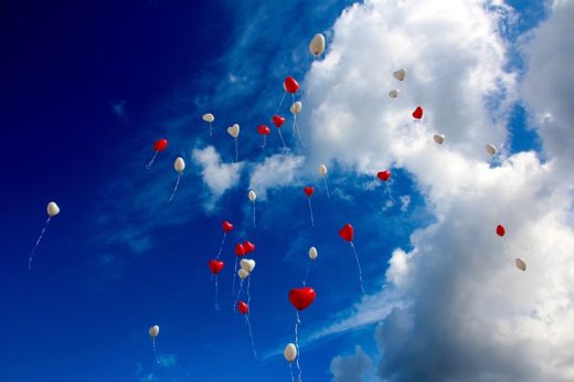 Herzchenluftballons am Himmel